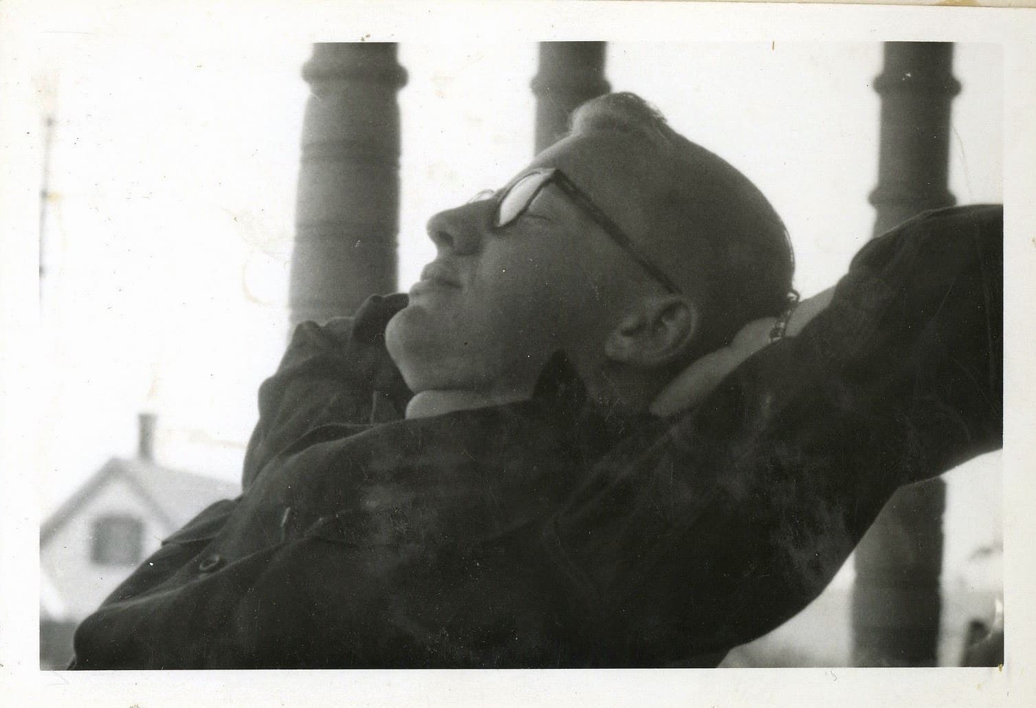 A man with glasses and hat is looking up.