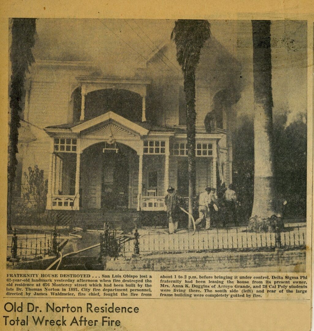 A newspaper clipping of an old house with smoke coming from the chimney.