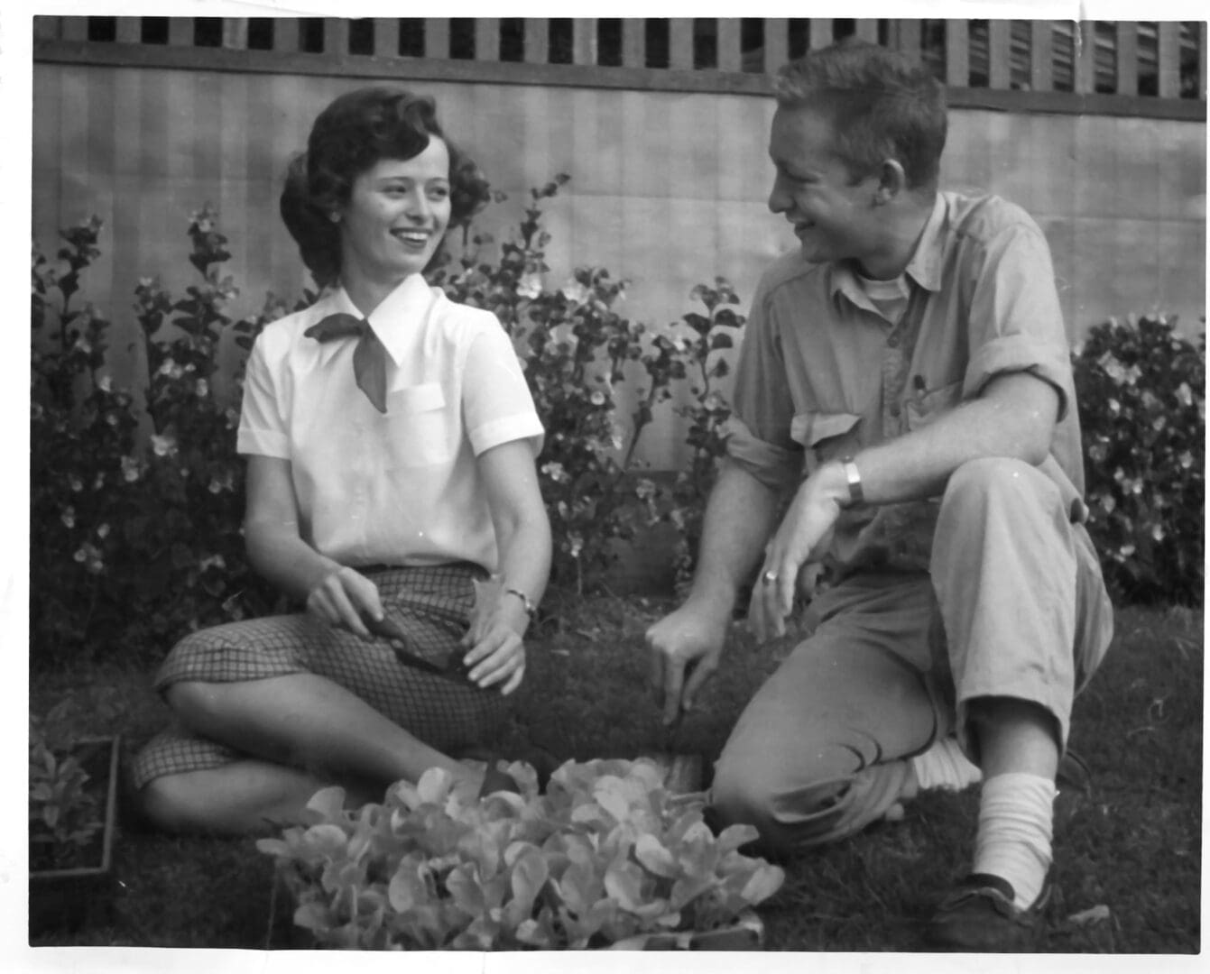 A man and woman sitting on the ground.