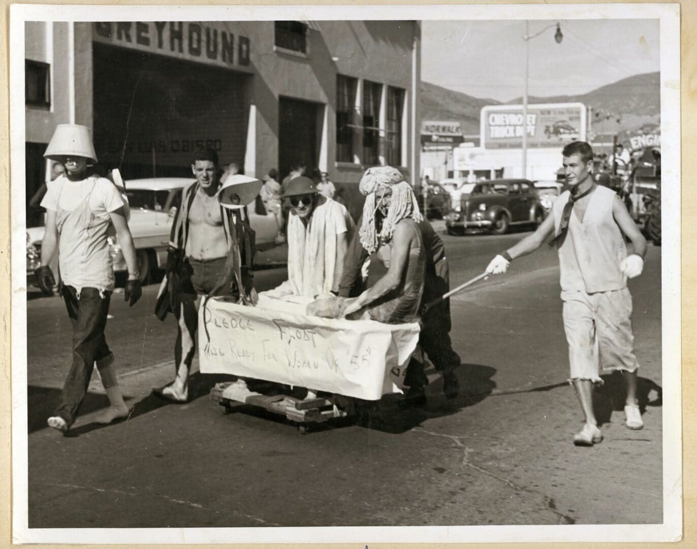 A group of men pushing a cart down the street.