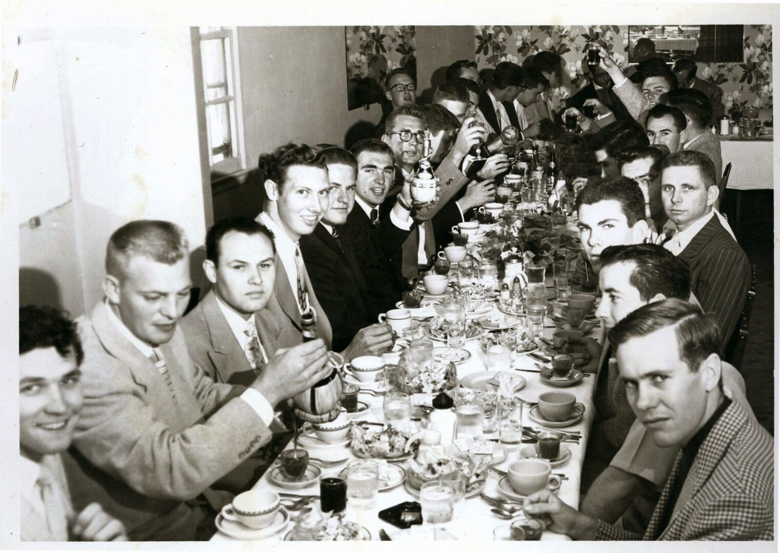 A group of men sitting at a table eating.