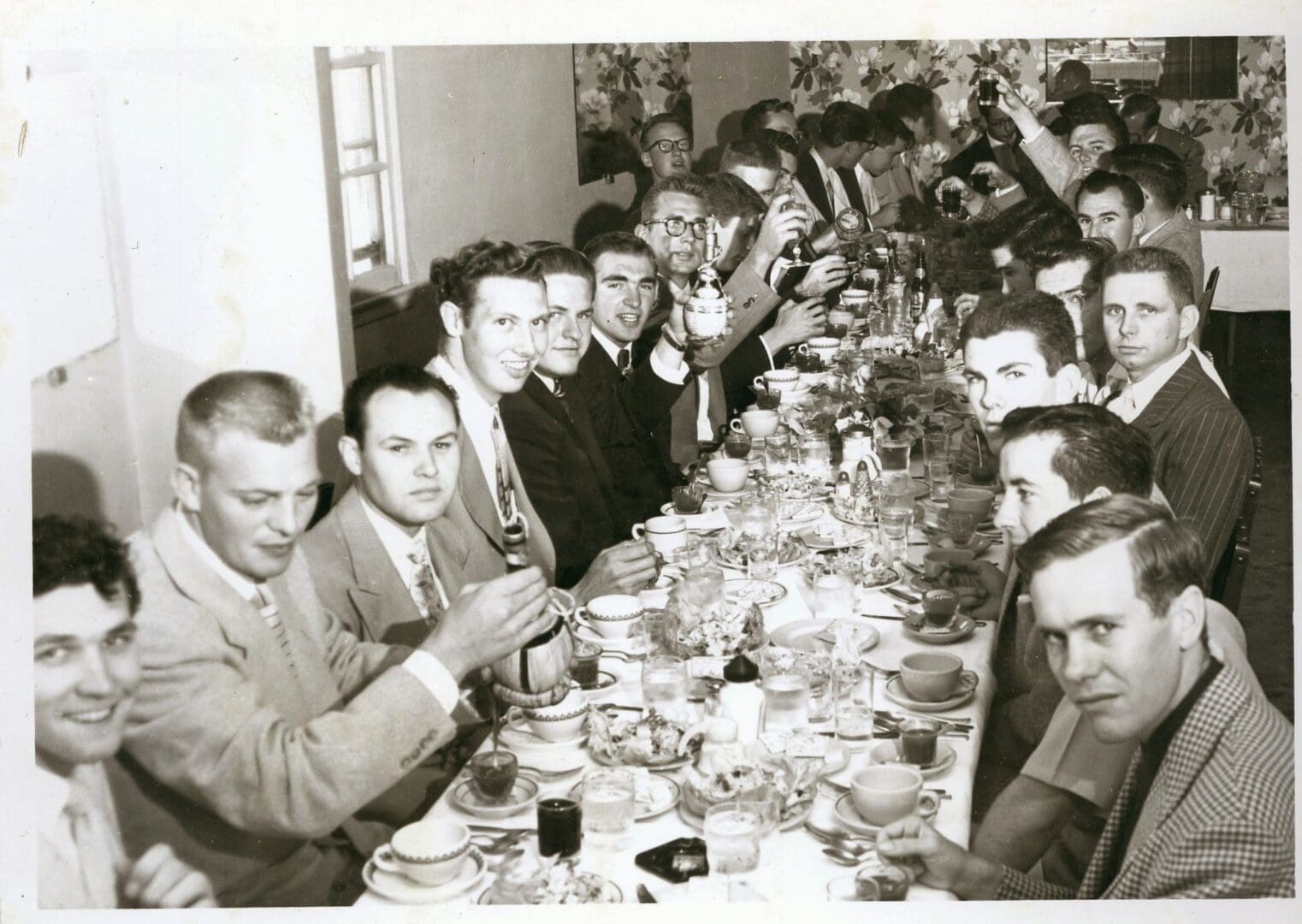 A group of men sitting at a long table eating.