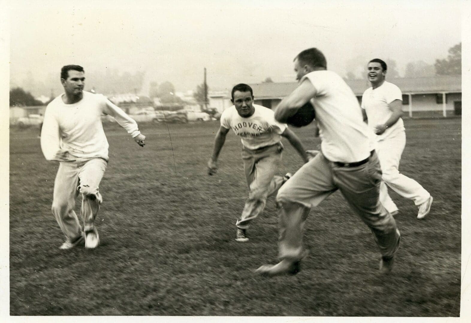 A group of men playing football on the field.
