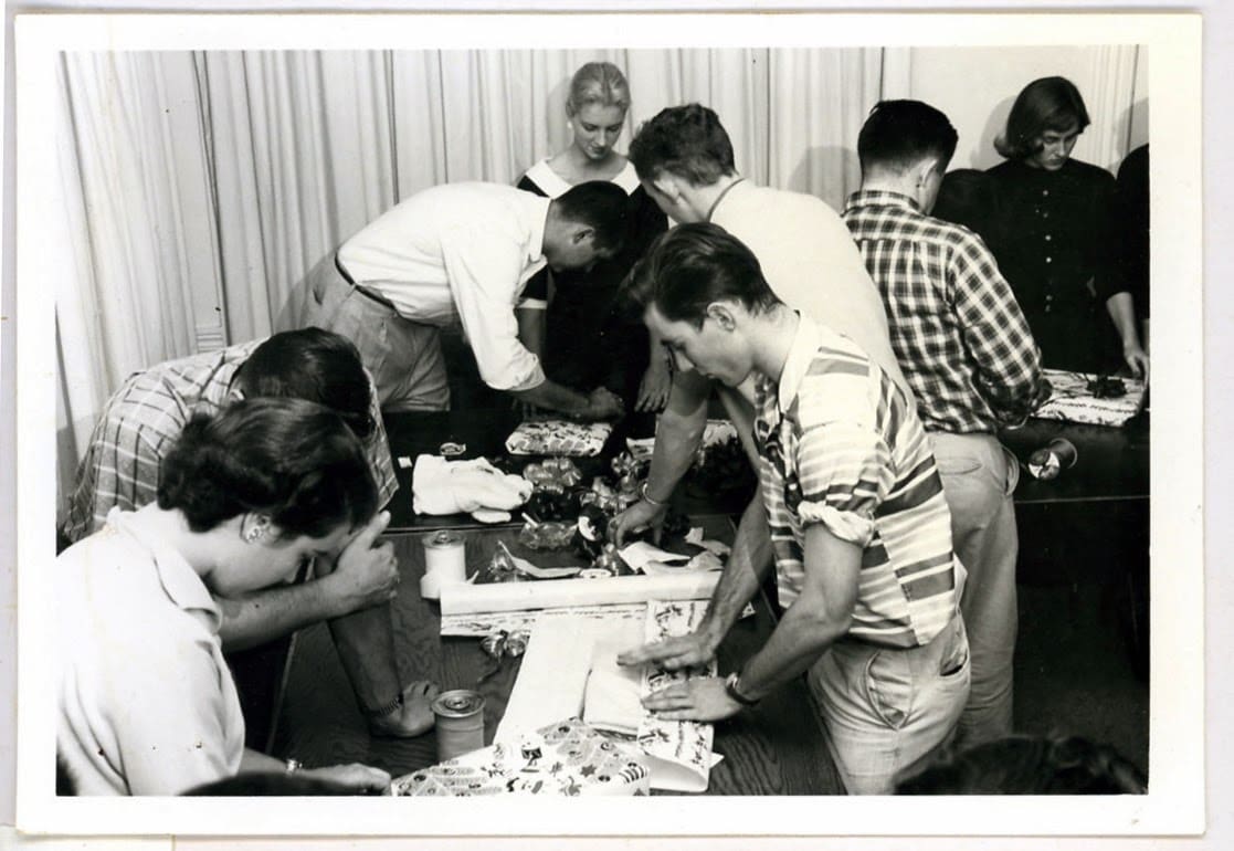 A group of people standing around a table.