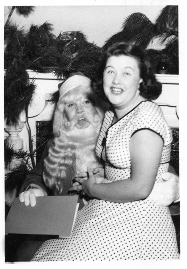 A woman sitting next to a cat with a box.