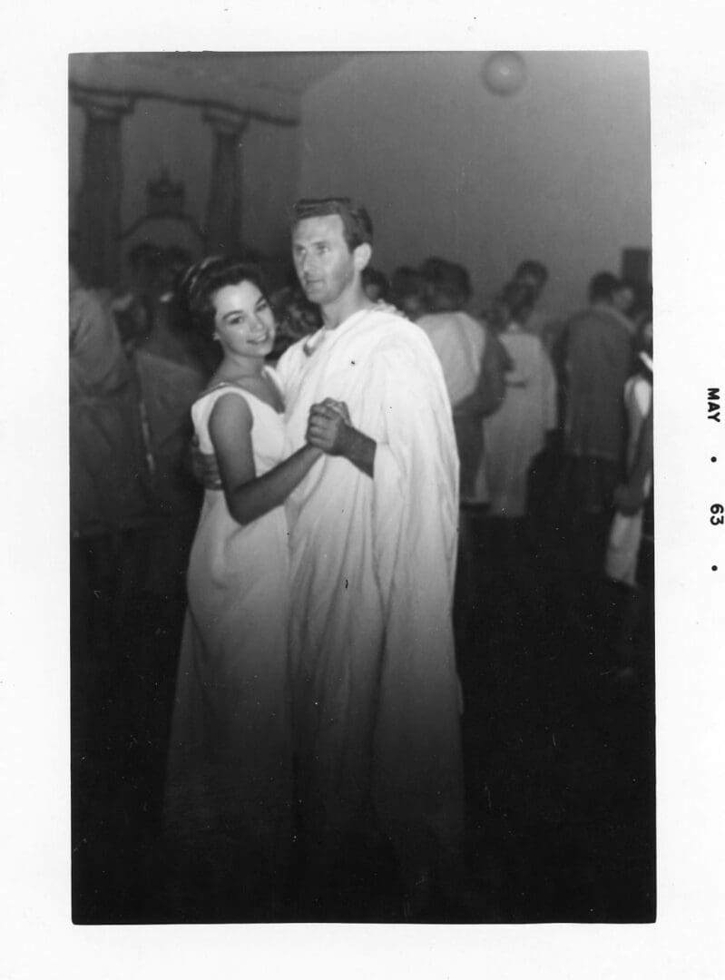 A man and woman dressed in roman garb dancing.