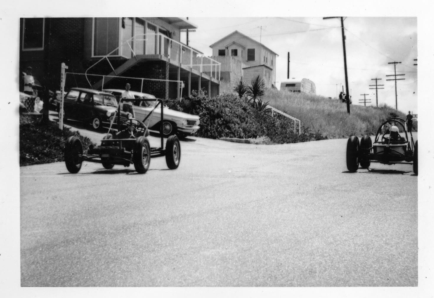 A black and white photo of an old car on the street.