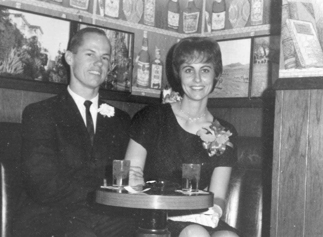 A man and woman sitting at a booth with drinks.
