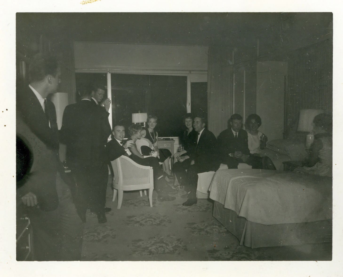 A group of people in a room with beds.