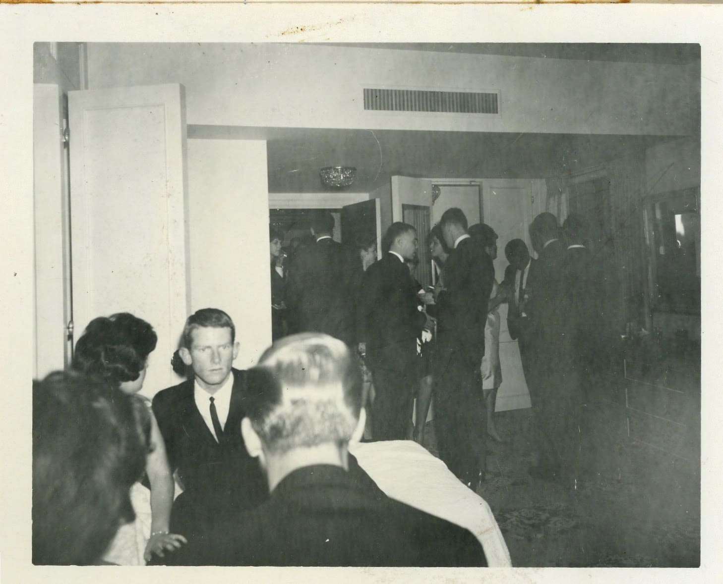 A group of people standing in an old photo.