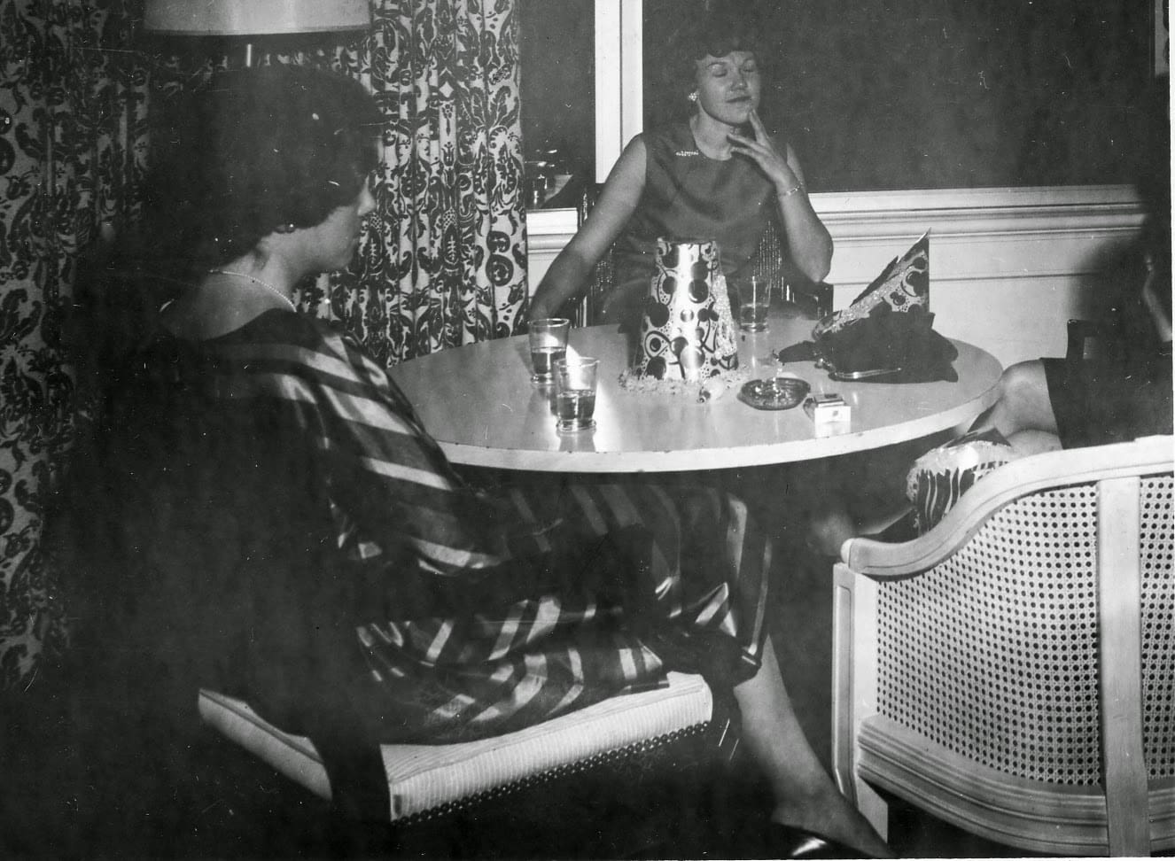 Two women sitting at a table with drinks.
