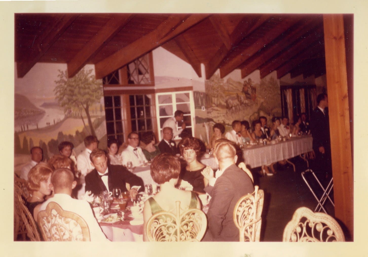 A group of people sitting at tables with food.