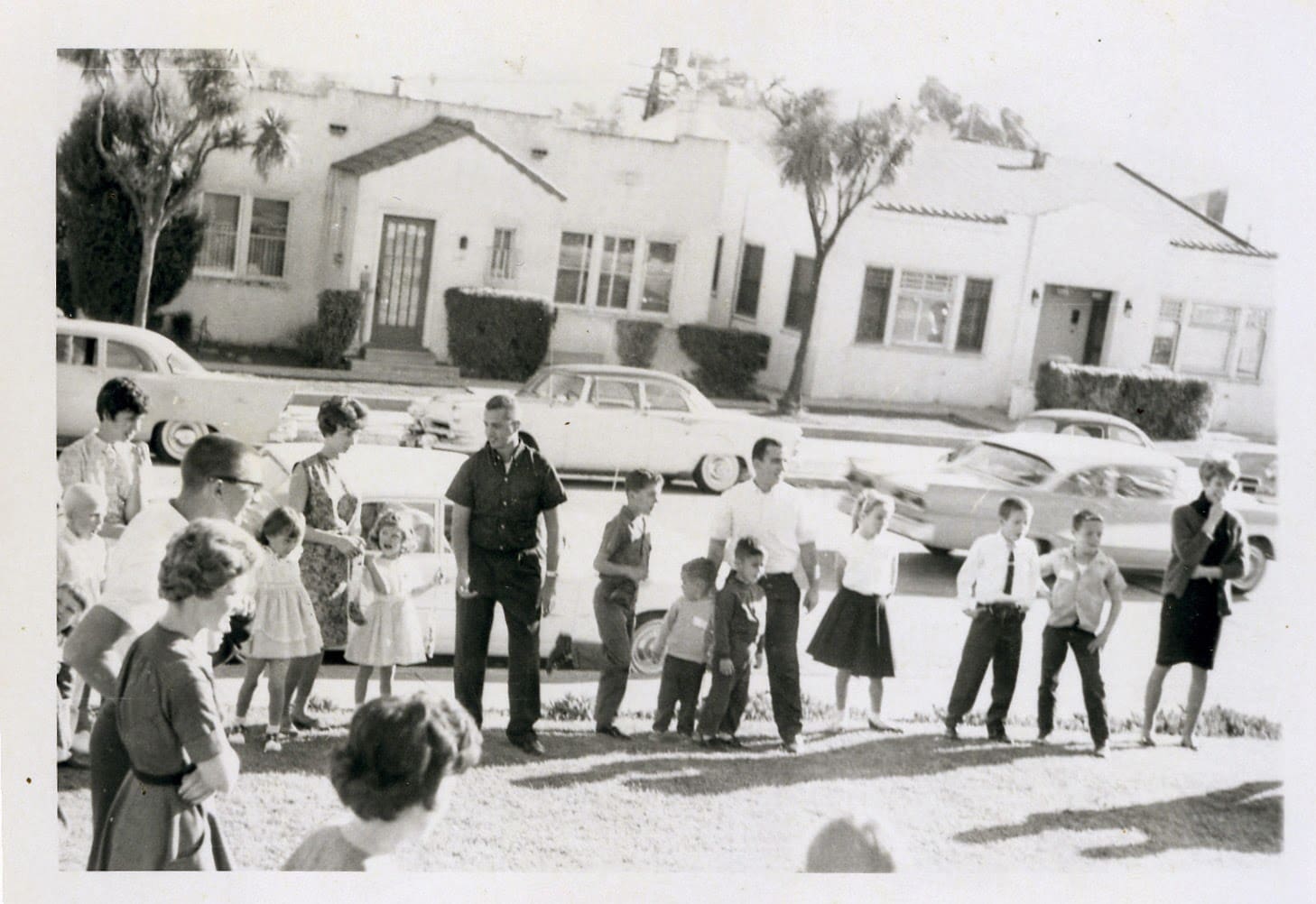 A group of people standing in front of some houses.