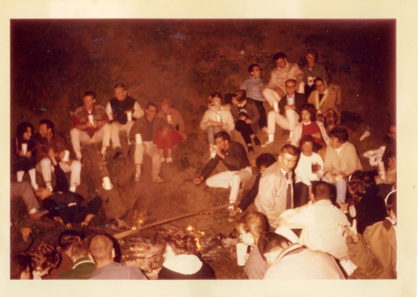 A group of people sitting around in the dark.