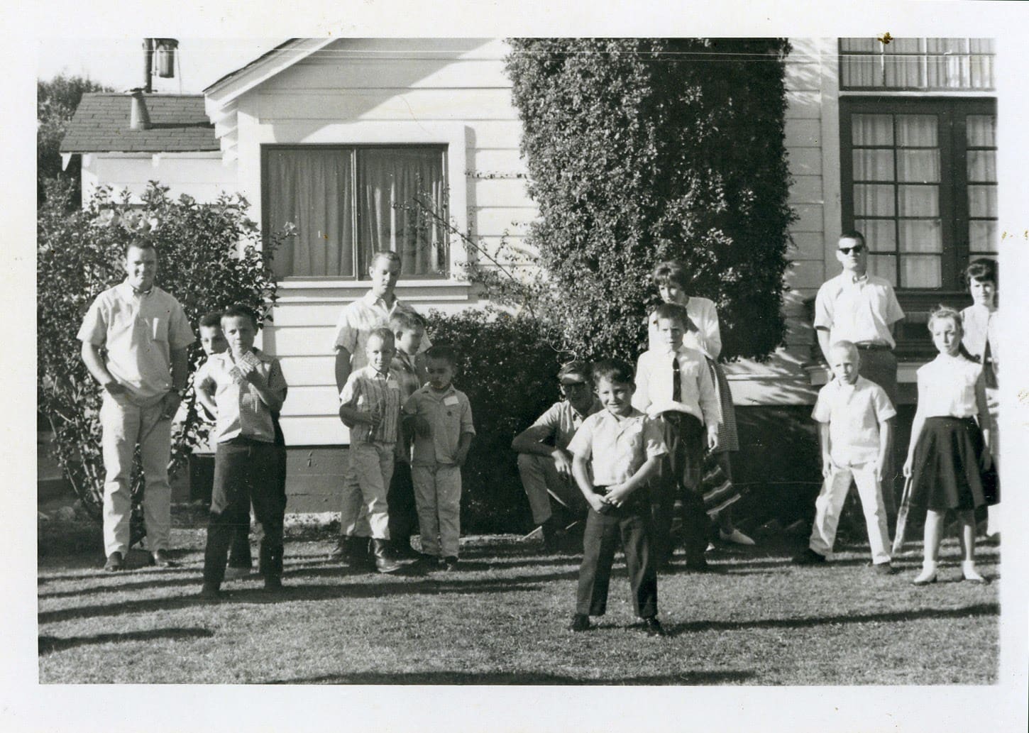 A group of people standing in front of a house.