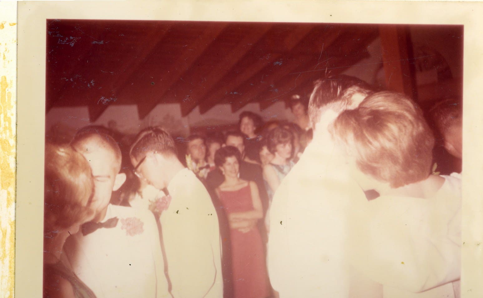 A group of people standing around in a room.