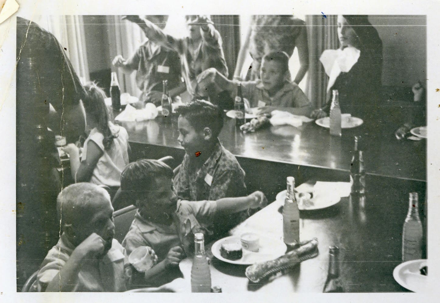 A group of people sitting at tables eating food.