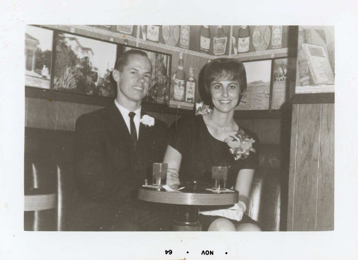 A man and woman sitting at a table with drinks.