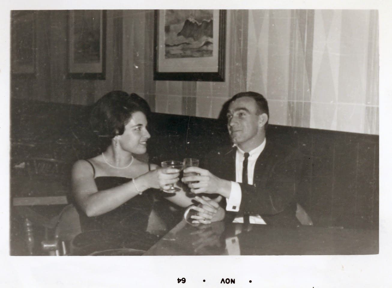 A man and woman sitting at a table with drinks.