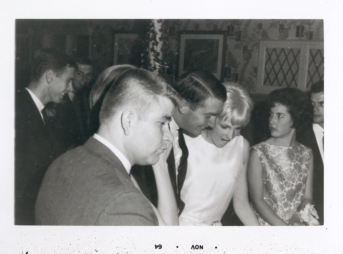 A man and woman are standing in front of another person.