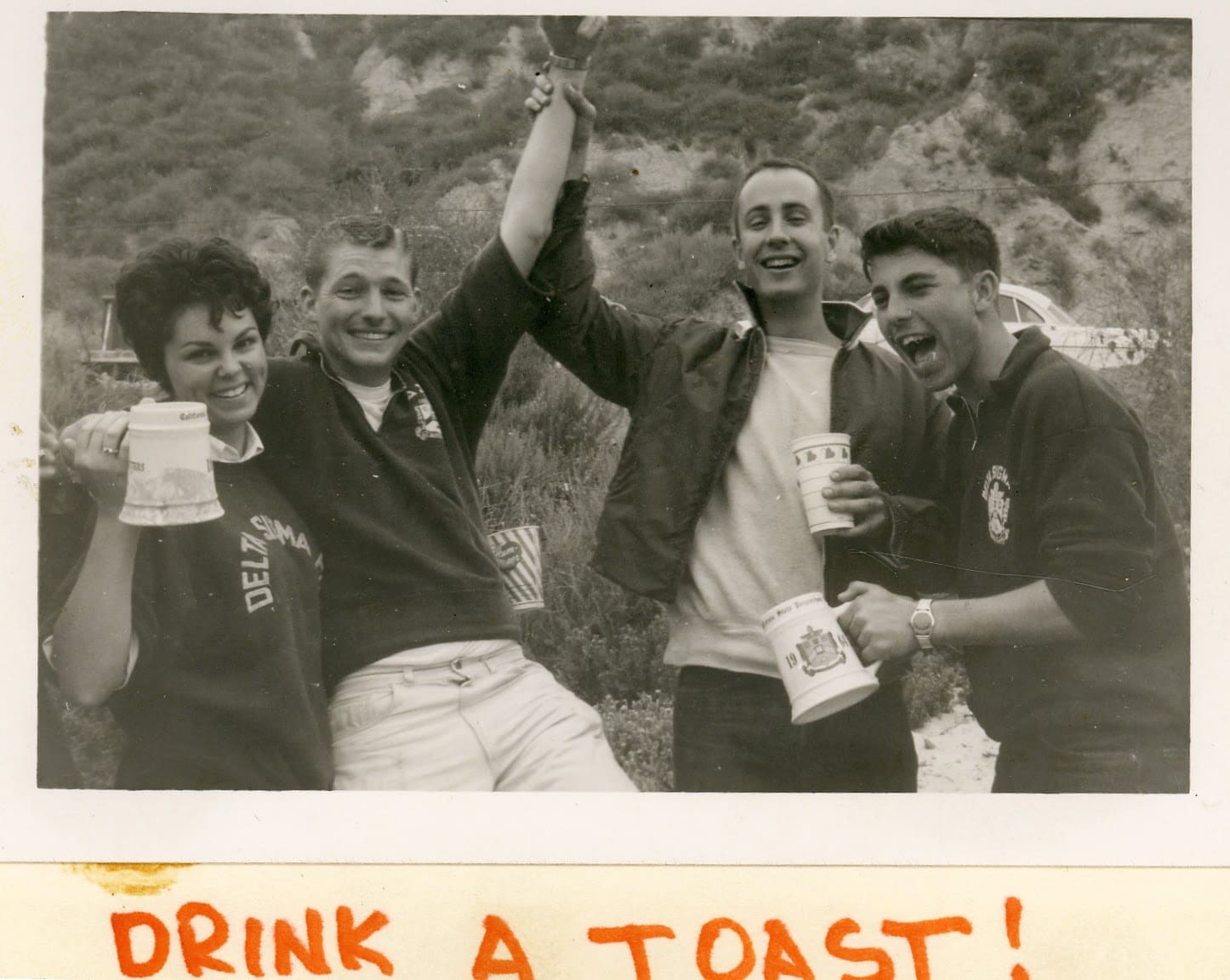 A group of men holding beers and smiling for the camera.