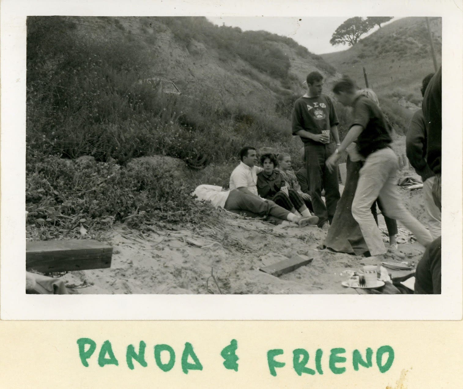 A group of people sitting on the beach.
