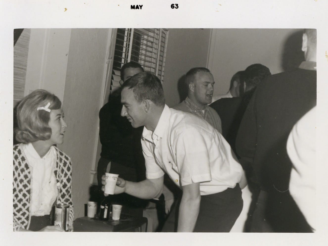 A group of people standing around drinking beer.