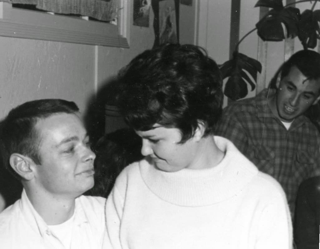 A man and woman are smiling at each other.