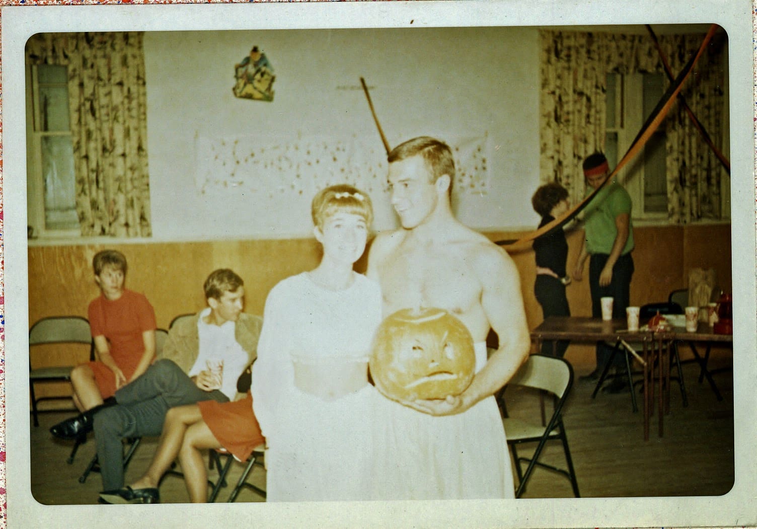 A man and woman standing in front of other people.