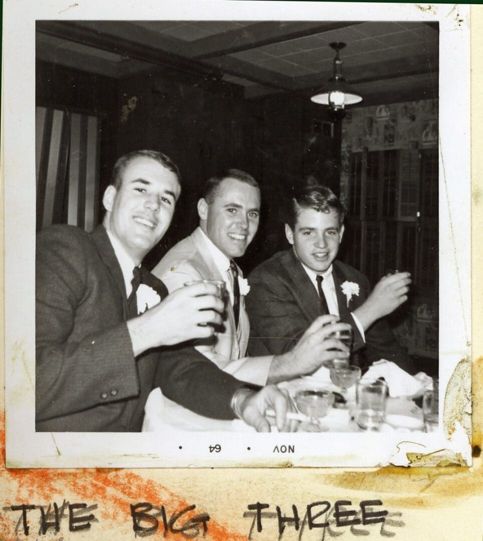 Three men are drinking beer at a party.