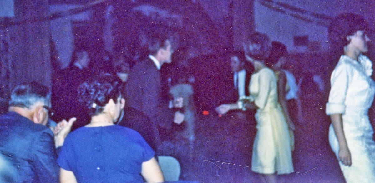 A group of people standing around in a room.