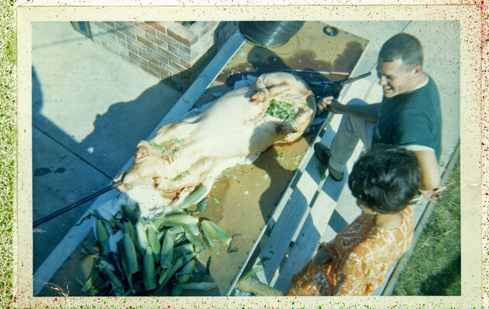 A dog laying on the ground next to two people.