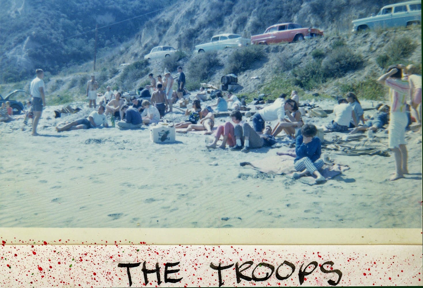 A group of people sitting on the beach