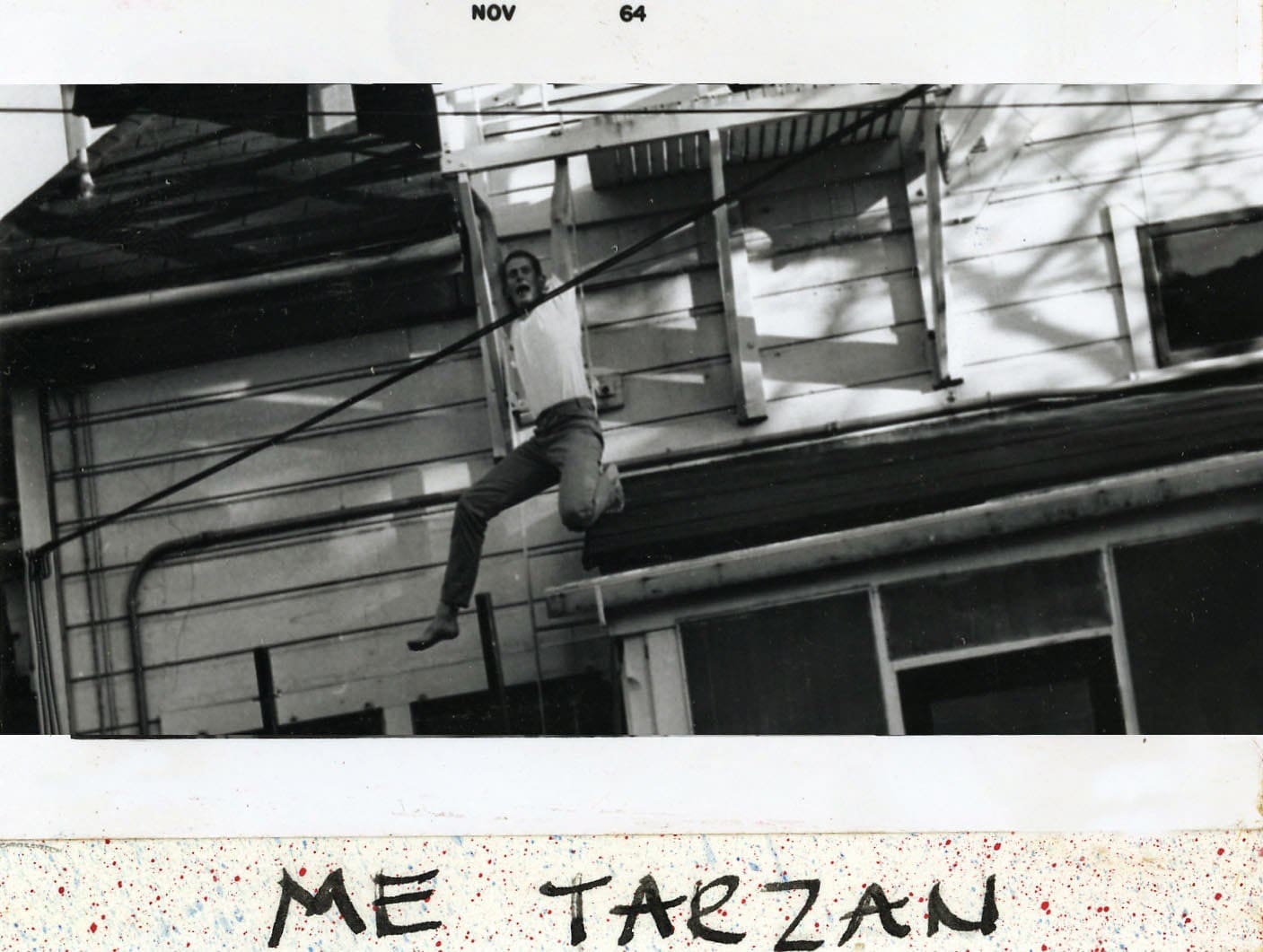 A man hanging from a rope on the side of a building.