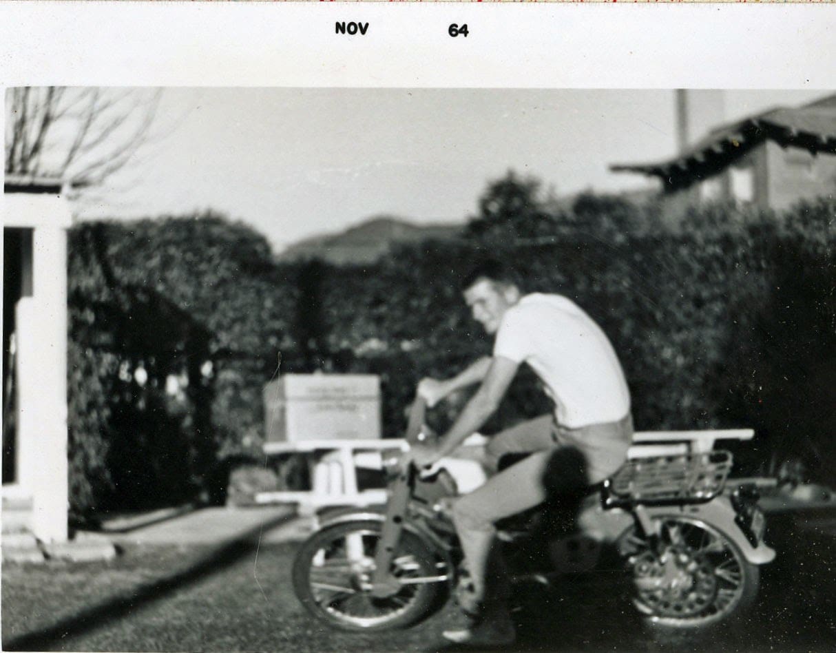A man sitting on the back of a motorcycle.