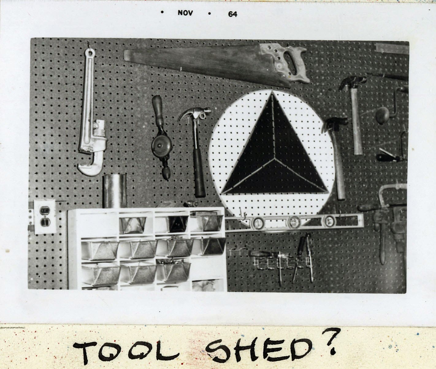 A black and white photo of tools on the wall.