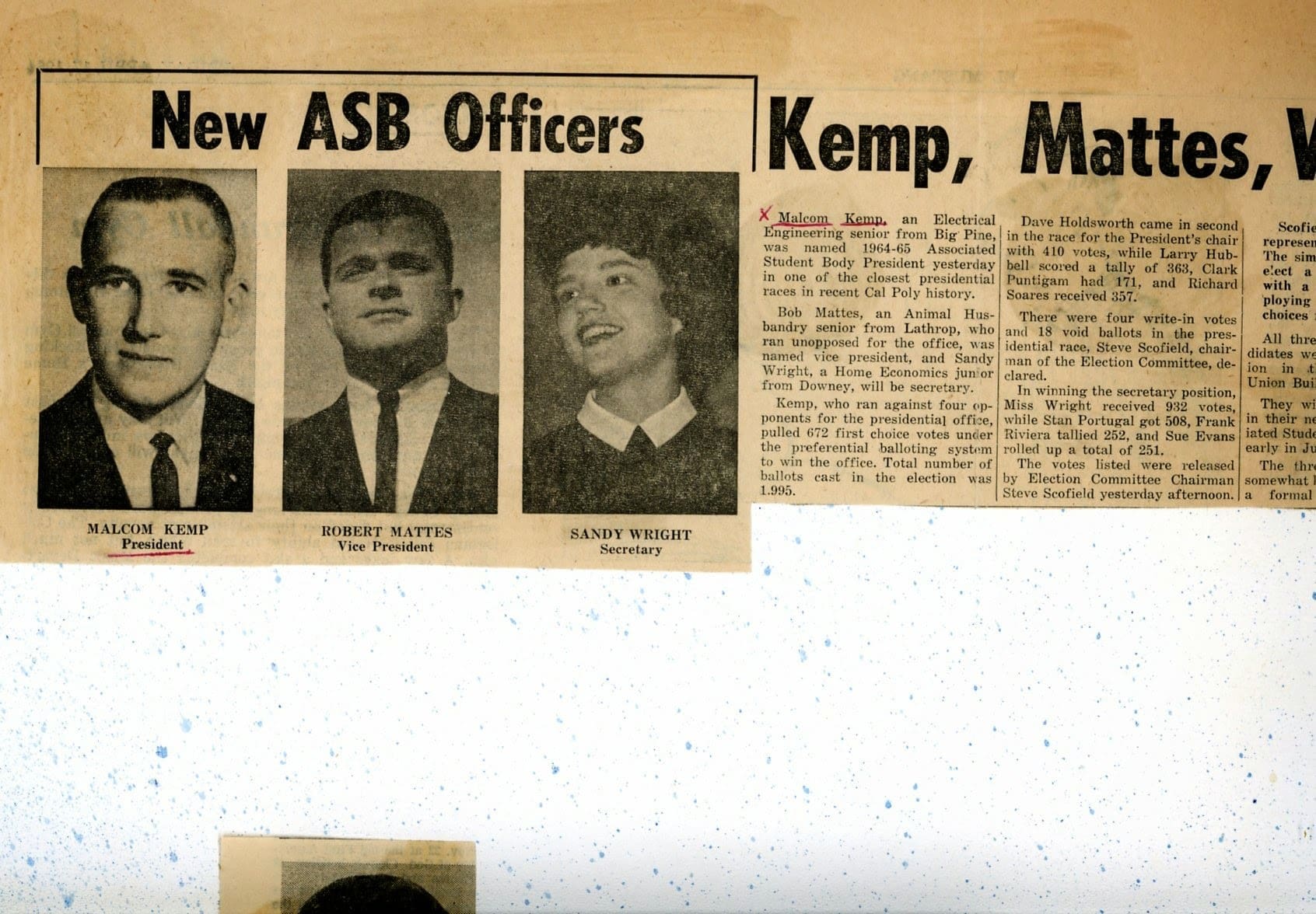 A newspaper clipping of three men and one woman.