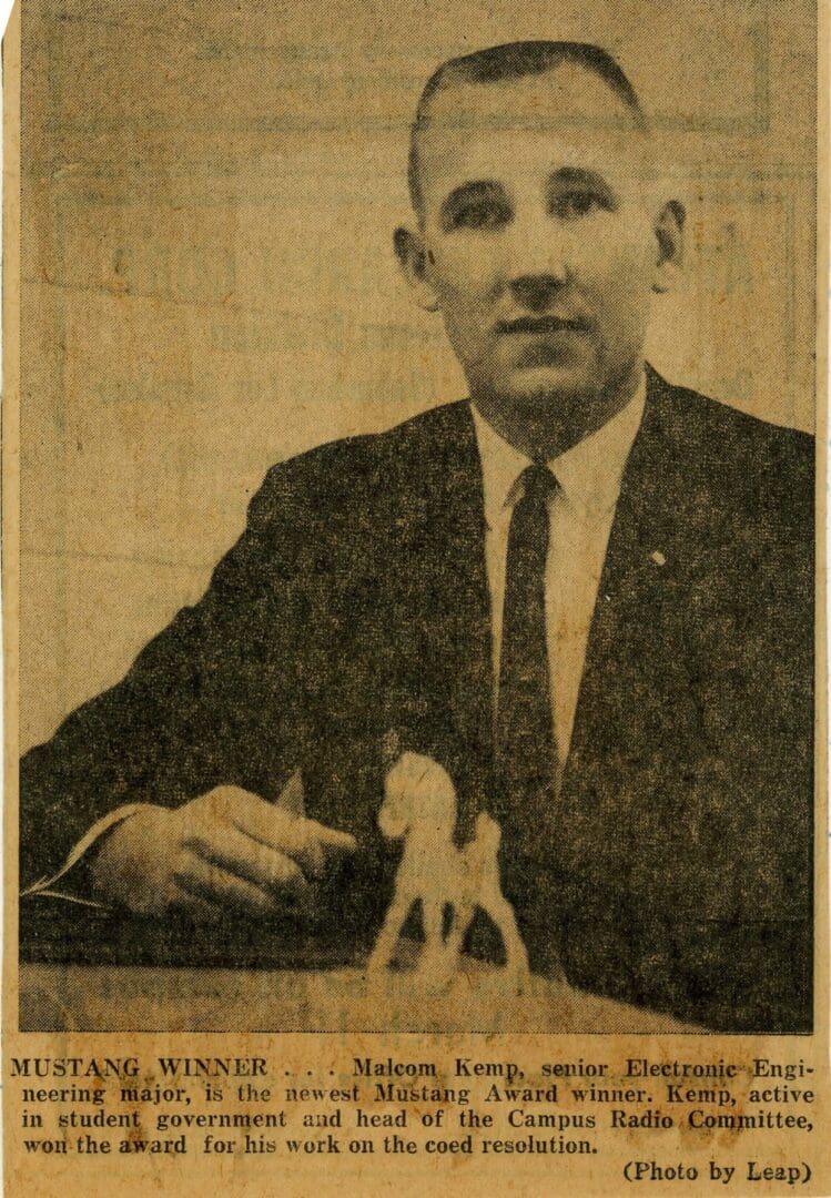 A man in suit and tie holding a pen.