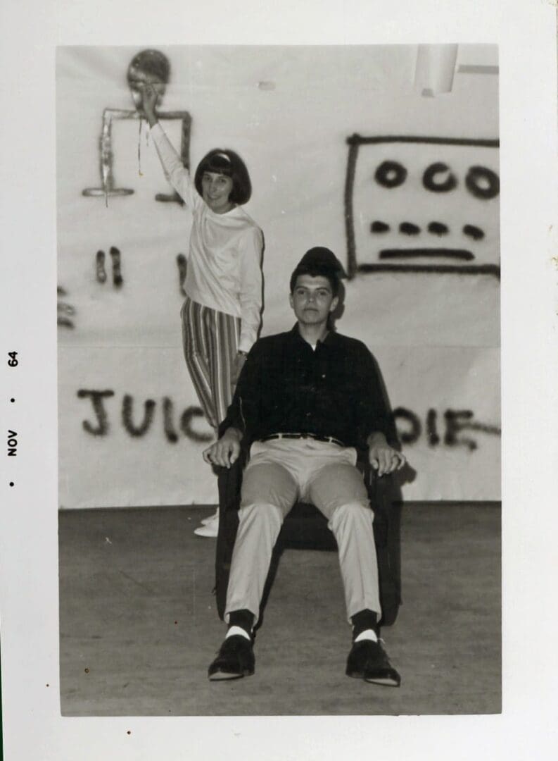 A man sitting in a chair next to a woman.