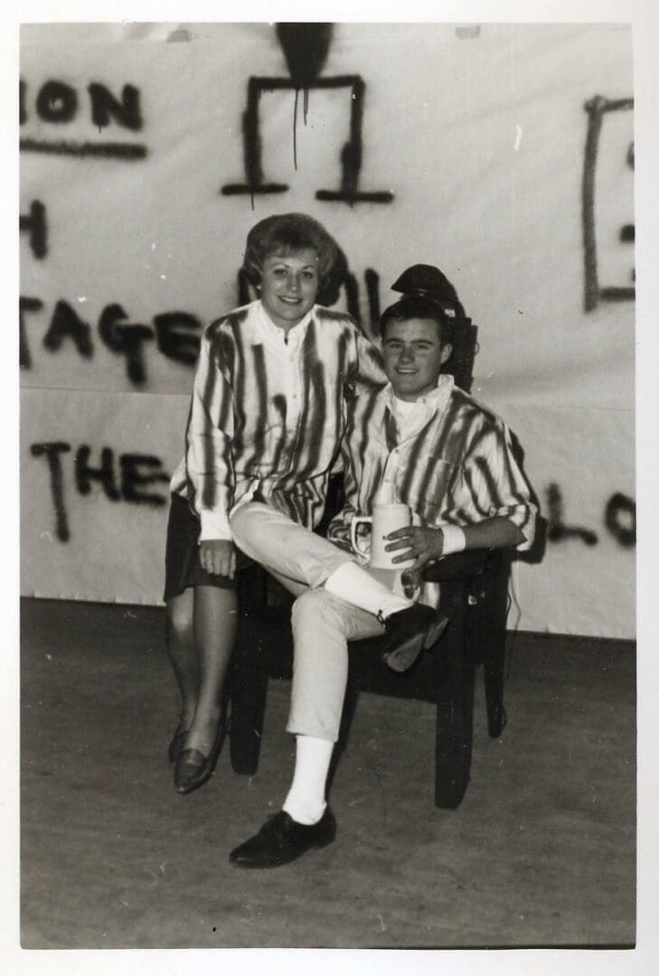 A couple of people sitting on top of a chair.