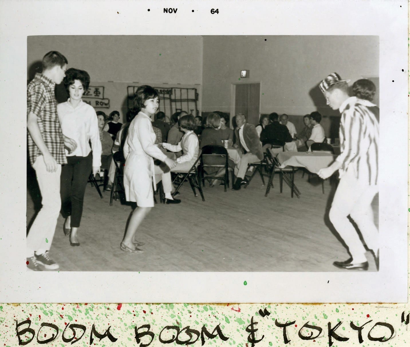 A group of people standing around in a room.