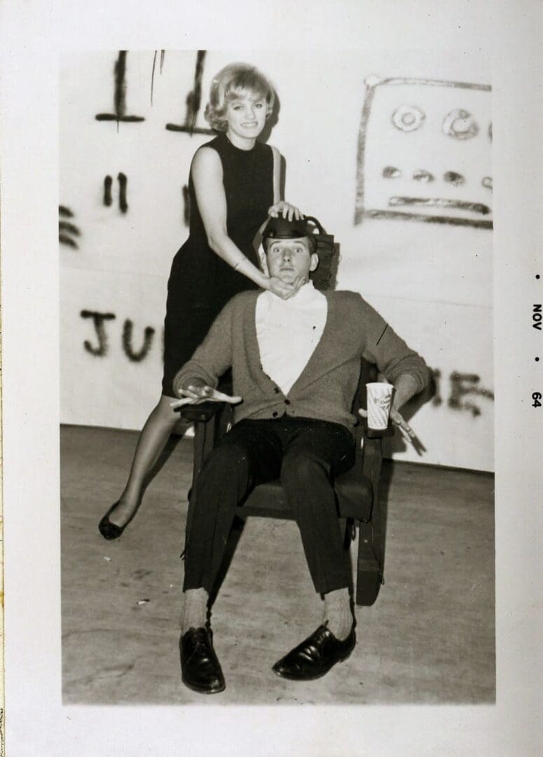 A man sitting in a chair next to a woman.