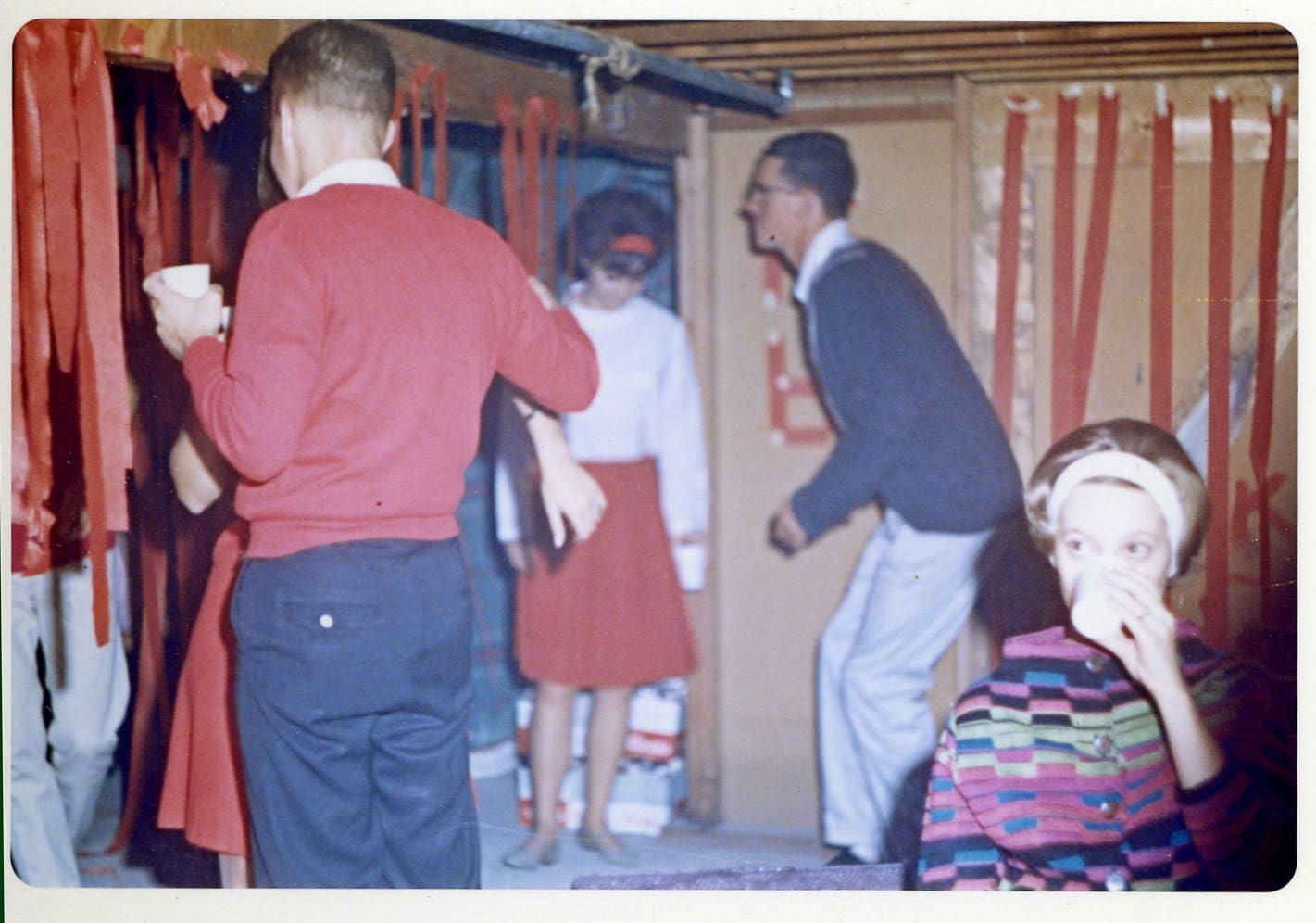 A group of people standing around in a room.