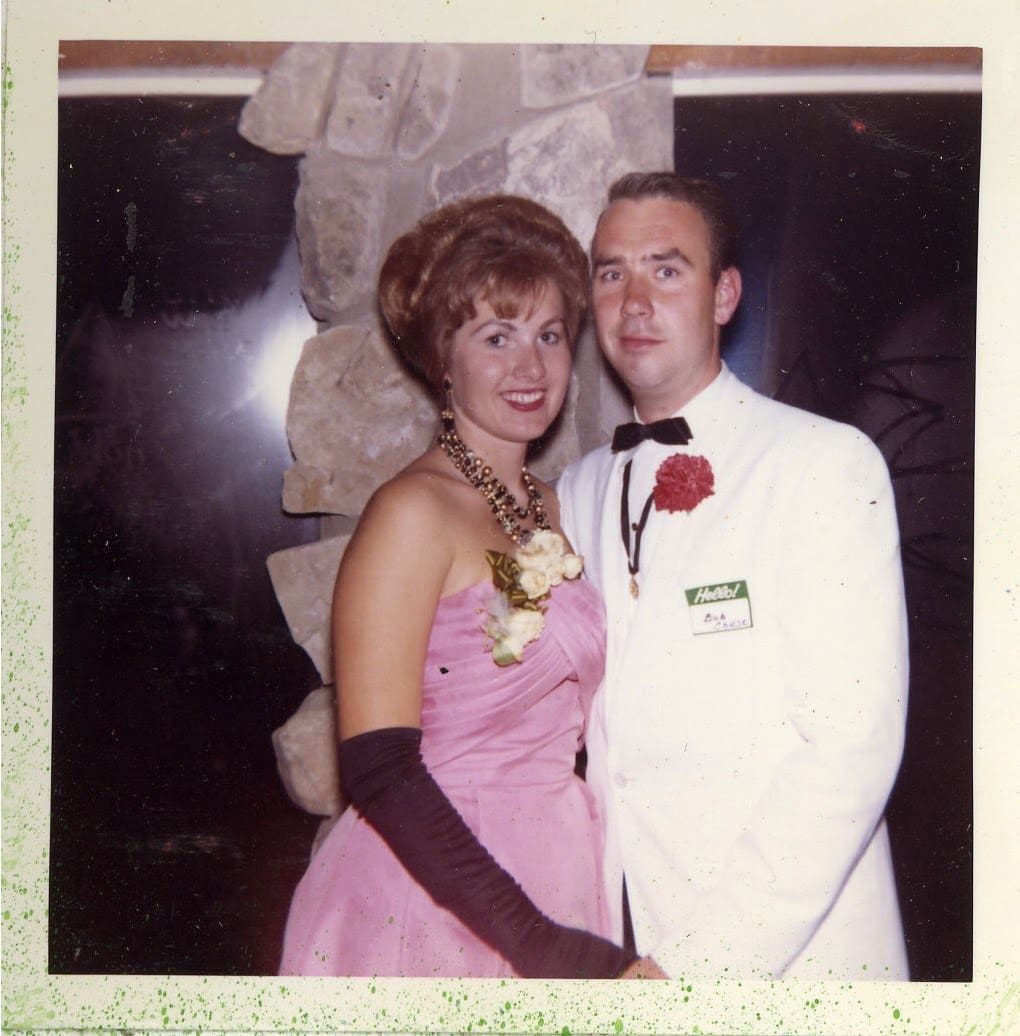 A man and woman pose for the camera in formal wear.