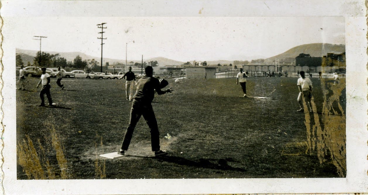 A man is swinging at the ball while another person watches.