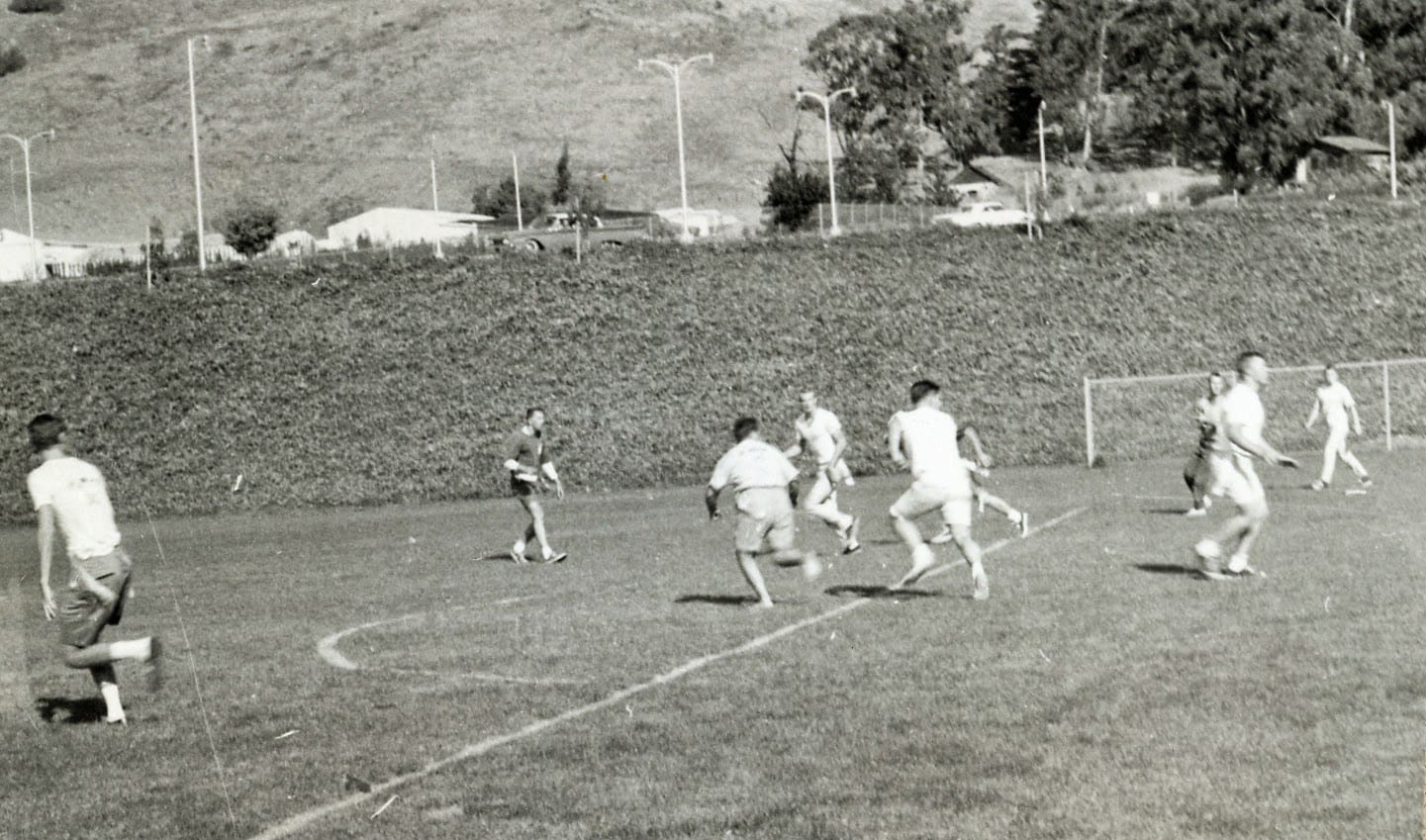 A group of men playing soccer on a field.